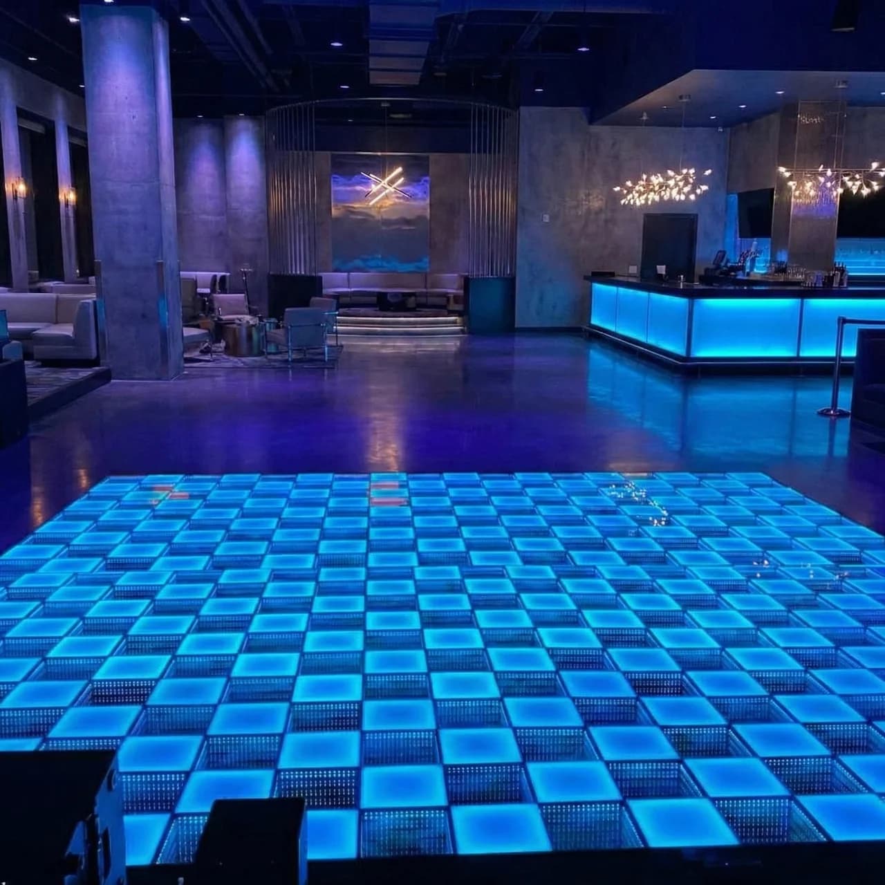 Frosted and mirrored LED dance floor tiles glowing blue