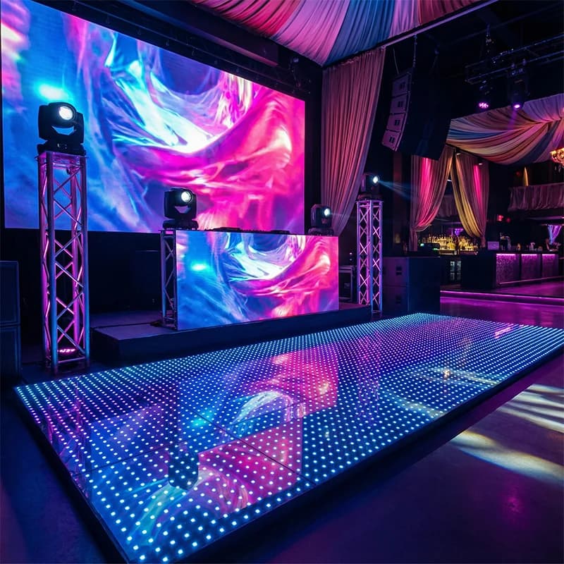 Pixel LED dance floor panels displaying colored patterns beside a DJ booth
