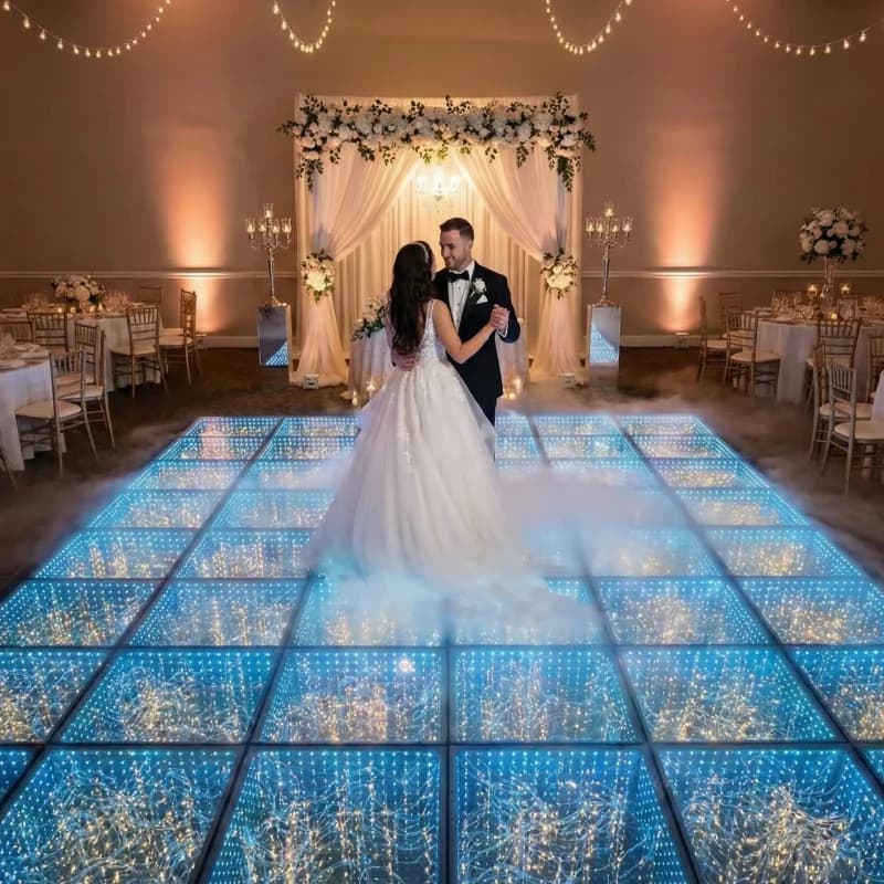 Mirrored star LED dance floor glowing blue in a wedding setting