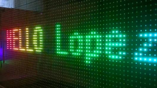 Close-up of a pixel LED dance floor displaying colored light and a text-like pattern